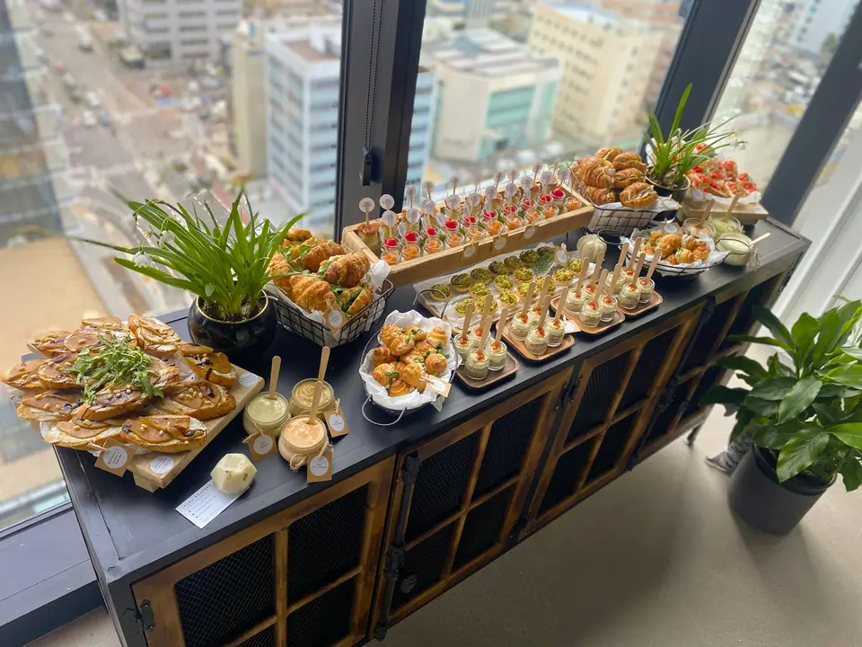 Appetizers arranged along a buffet table beside an office window